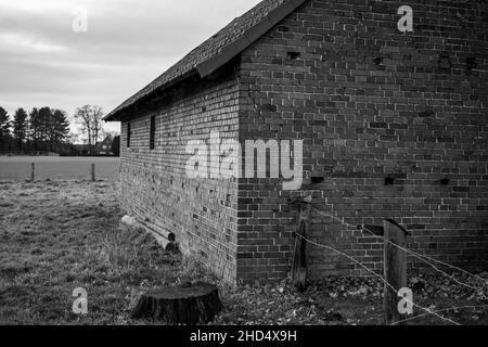 Old wind warped brick barn in black and white Stock Photo