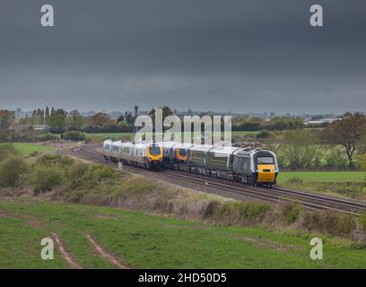 Crosscountry Trains Voyager and Great Western railway castle high speed train passing in the Gloucestershire countryside with copy space Stock Photo