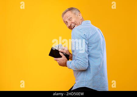 Excited mature man holding taking money from wallet Stock Photo