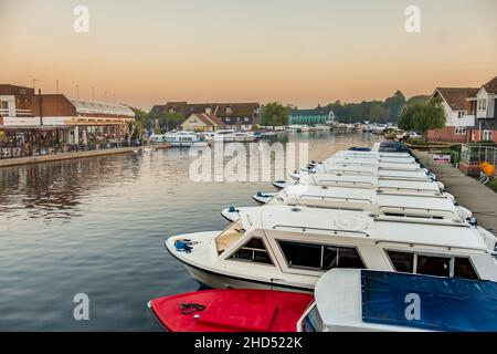Hire boats at sunset at Wroxham on the Norfolk broads. Stock Photo