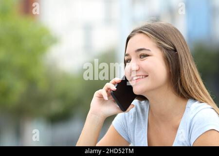 Happy teen talking on mobile phone in the street Stock Photo