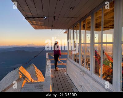 Girl watching sunrise at Mount Pilchuck in the North Cascades Stock Photo