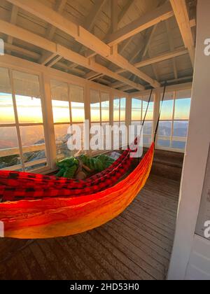 Hammocks hanging inside Mount Pilchuck fire lookout at sunset Stock Photo