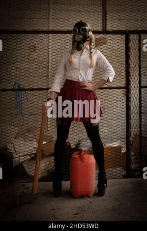 Woman with toxic protective mask holding axe in an underground warehouse Stock Photo