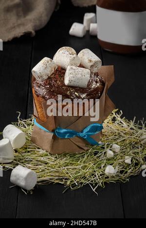 Easter cake with marshmallows on chocolate icing wrapped in kraft Stock Photo