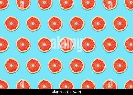 Grapefruit Slices on a Blue Background in a Pattern Stock Photo