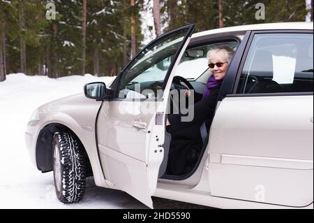 Stylish elderly woman sitting in her car. Stock Photo