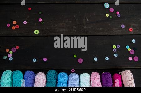 colorful woolen balls on brown wooden floor with colorful buttons Stock Photo