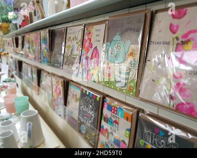 Closeup of handmade gift cards on the shelf organized in a row and cups on the table Stock Photo