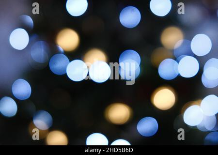 Blurred, out of focus Christmas tree with lights exhibiting bokeh balls giving a dream-like festive effect Stock Photo