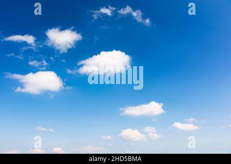 sky with fluffy clouds. white cumulus sparse cloudscape on a deep blue gradient of atmosphere. sunny summer weather. beautiful nature background. mete Stock Photo