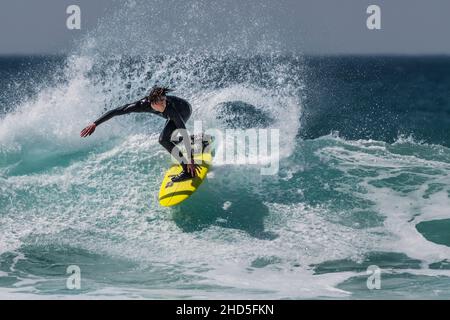 Spectacular action as a surfer rides a wave at Fistral in Newquay in Cornwall. Stock Photo