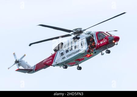 Sikorsky S-92A G-MCGY HM Coastguard Helicopter based at Cornwall Airport Newquay flying overhead on an emergency callout at Fistral in Newquay in Cornwall. Stock Photo