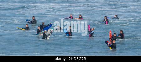 A panoramic image of holidaymakers bodyboarding in the sea at Fistral in Newquay in Cornwall. Stock Photo