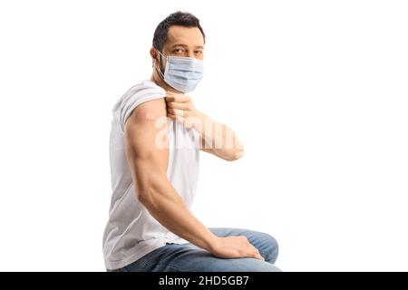 Young man with a mask showing his arm with a vaccine patch isolated on white background Stock Photo