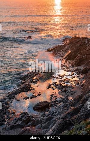 A spectacular sunset over rockpools in Fistral Bay on the coast of Newquay in Cornwall. Stock Photo