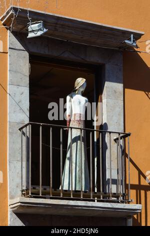 A curious life size stylized sculpture of a woman stands mannequin-like on the balcony of the EXIM Galeria, specializing in local artists, SMA, MX Stock Photo