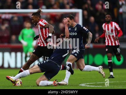 BRENTFORD, ENGLAND - JANUARY 02: Ivan Toney of Brentford is tackled by Josh McGinn of Aston Villa during the Premier League match between Brentford and Aston Villa at Brentford Community Stadium on January 2, 2022 in Brentford, England. (Photo by Ben Peters/MB Media) Stock Photo