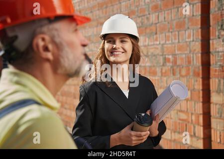 Friendly civil engineer smiling to construction worker Stock Photo