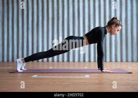 Fit woman doing full plank exercise works on abdominal muscles , working out. Stock Photo