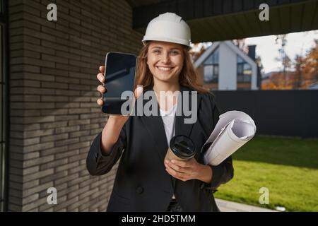 Excited woman showing her phone to camera Stock Photo