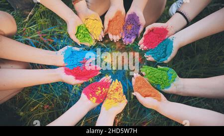 Holi paints in the hands of girls. Hands in a circle. Stock Photo