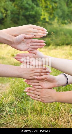 Girlfriends put their palms of their hands on top of each other. Stock Photo