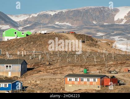 Old graveyard with snow patches and mountains in Ittoqqortoormiit, Lincoln Land, Scoresby Sund, Greenland Stock Photo