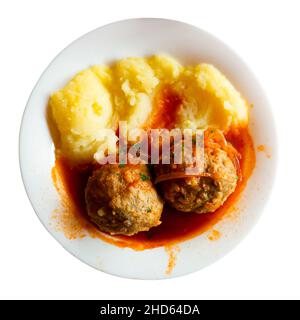 Fresh hot mashed potatoes and meatballs with gravy on plate. Russian cuisine Stock Photo