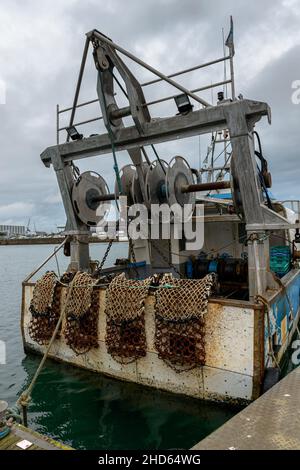Cherbourg-en-Cotentin, Normandy, France. 24th Dec, 2021. A trawler with dredge nets specialized in scallops is seen from the rear at the port of Cherbourg.The fishing industry in the port of Cherbourg (Manche) is preparing for the first year of the post-Brexit fishing season. 40% of the volumes being fished come from the British waters of Jersey and Guernsey for which the fishermen have obtained licenses. (Credit Image: © Laurent Coust/SOPA Images via ZUMA Press Wire) Stock Photo