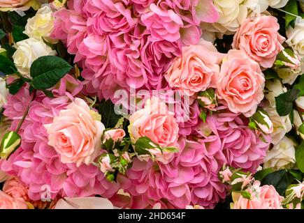 Rose and hydrangea flowers, top view of large bouquet of artificial flowers. Beautiful background of floral design with pink and white flowers. Nature Stock Photo