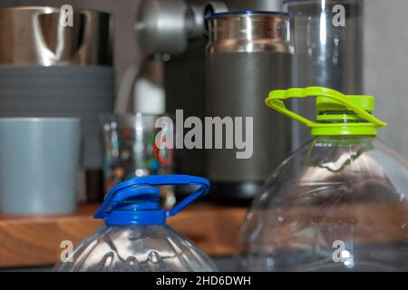 closeup of two plastic water bottles and household appliances in the blurred background Stock Photo
