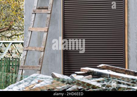 unfinished house protected with metal shutter on entrance door Stock Photo