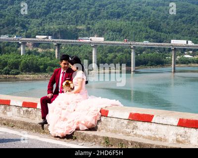 Hue, Vietnam - March 13, 2016: Couple posing for photos during wedding photography session in a scenic location overlooking Lap An lagoon Stock Photo
