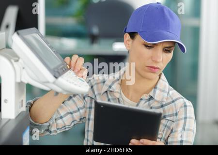 young craftswoman fixing a printer Stock Photo
