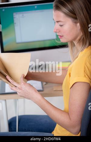 cheerful businesswoman standing with folder Stock Photo