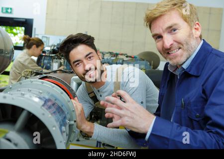 two workers in blue uniform working with industrial object Stock Photo