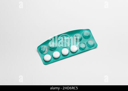 ATHENS / GREECE - DECEMBER 30 2021: Aspirin pills in opened green blister package, white background Stock Photo