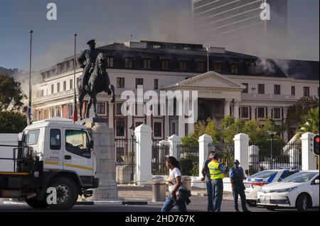 South Africa's national parliament smouldering after a fire broke out in the early morning hours of 2 January 2022 in central Cape Town Stock Photo