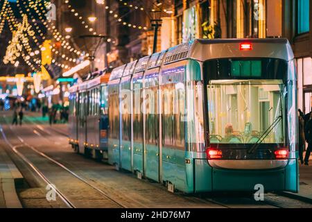 Helsinki, Finland. Tram Departs From Stop On Aleksanterinkatu Street. Night Evening Christmas Xmas New Year Festive Street Illumination. Beautiful