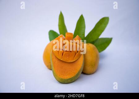 Fresh Delicious Slice Yellow Ripe Mango with Green leaf on isolated Background Stock Photo