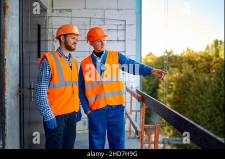 Two builder standing talking at construction site Stock Photo
