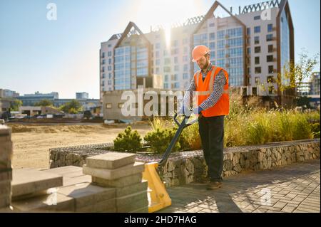 Builder using hand loader at construction site Stock Photo