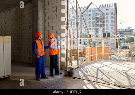 Two builders standing and talking about construction Stock Photo