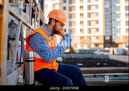 Construction worker eating sandwich during lunch break Stock Photo