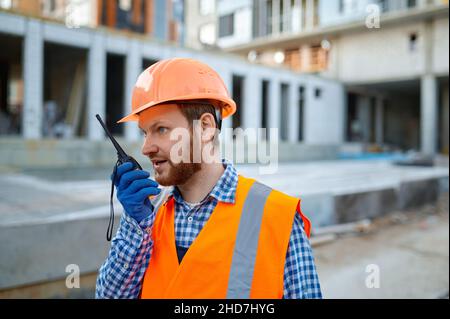 Builder worker using walkie-talkie on construction site Stock Photo