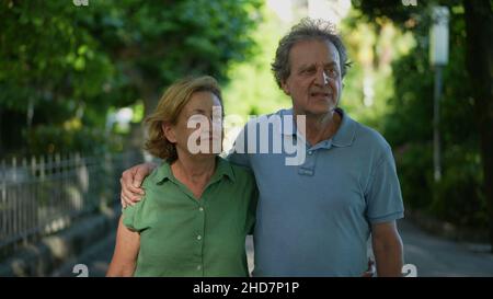 Happy senior couple walking together in afternoon walk Stock Photo