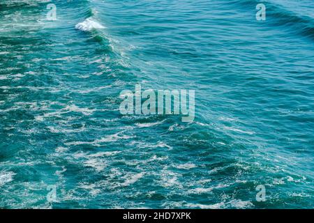 safire colored waves of the sea with its surf approaching the beach seen from above Stock Photo