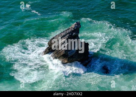 safire colored waves of the sea with its surf approaching the beach seen from above Stock Photo
