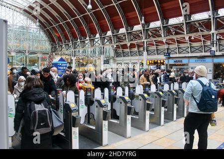 masked customers at ticket barrier at paddington station london england uk Stock Photo